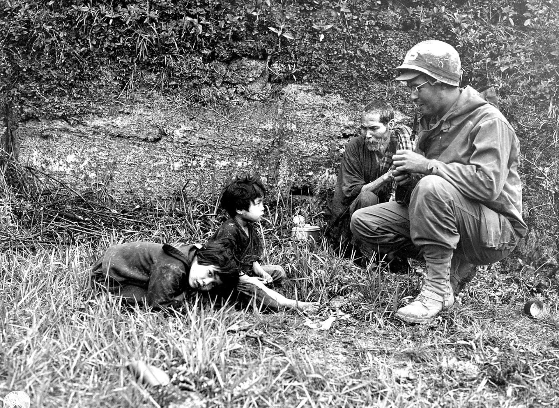 Pfc. Robert A. Vincent, L.I., N.Y., offers K rations to Okinawan children